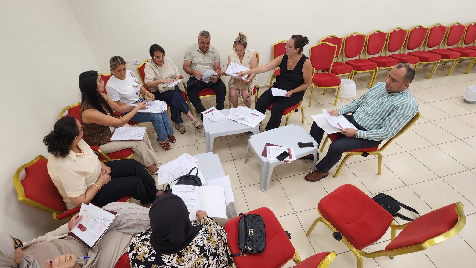 Committee members pass documents around a circle of chairs during the committee discussions.