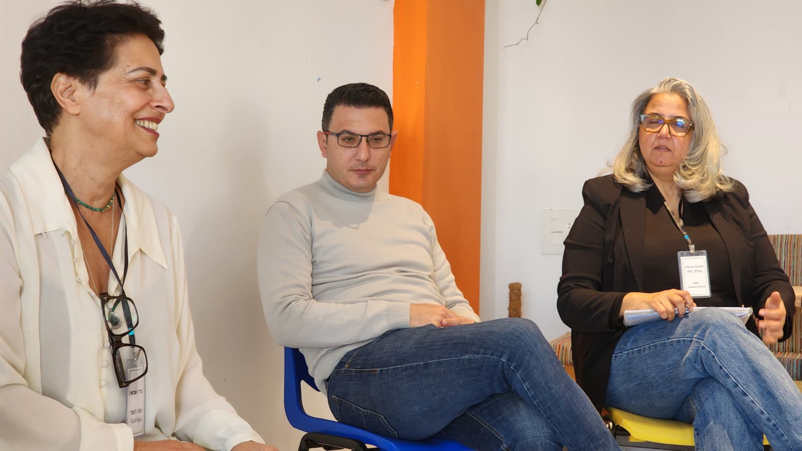 A participant laughing between two others during the working session.
